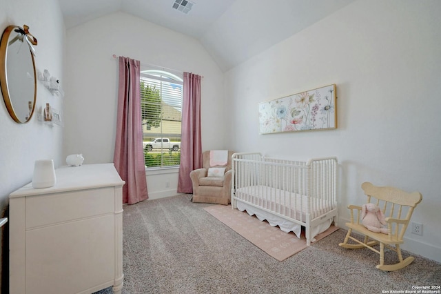 bedroom featuring a nursery area, light colored carpet, and lofted ceiling