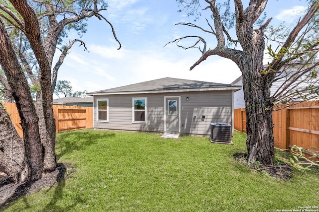 rear view of house with a lawn and central air condition unit