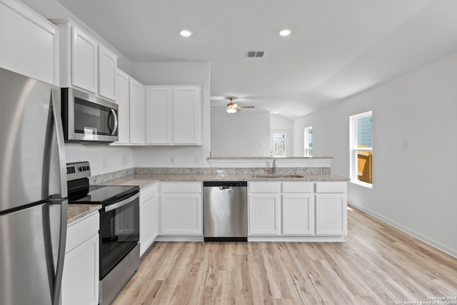 kitchen with light stone countertops, stainless steel appliances, ceiling fan, light wood-type flooring, and white cabinets