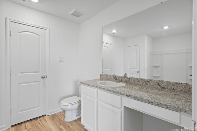 bathroom with hardwood / wood-style floors, toilet, and vanity