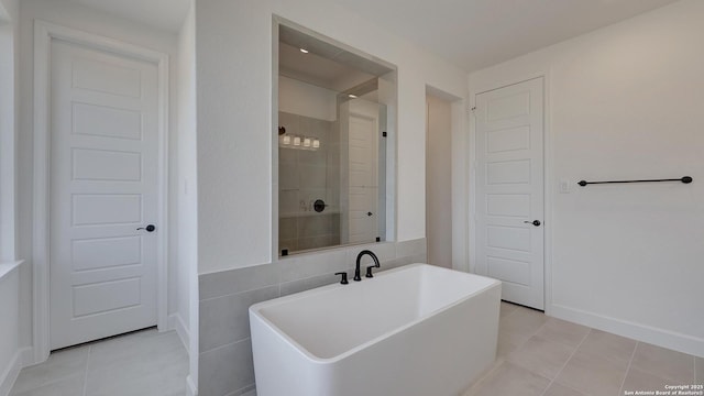 bathroom with tile patterned floors, a bathing tub, and tile walls