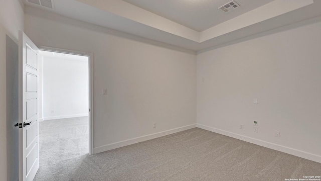 carpeted spare room featuring baseboards and visible vents