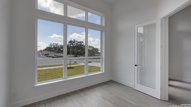 spare room featuring light wood-style floors and baseboards