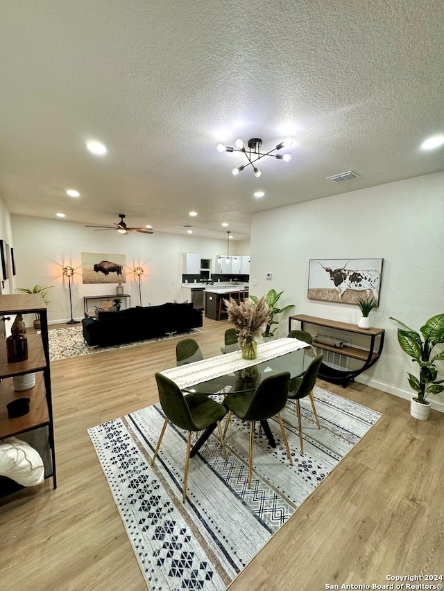 dining space with a textured ceiling, ceiling fan, and light wood-type flooring