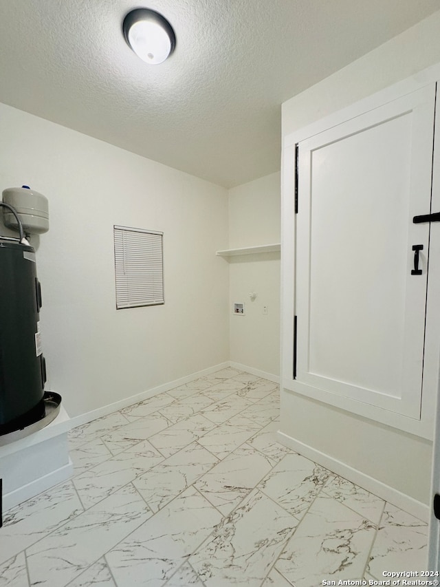 laundry area featuring washer hookup, a textured ceiling, and electric water heater