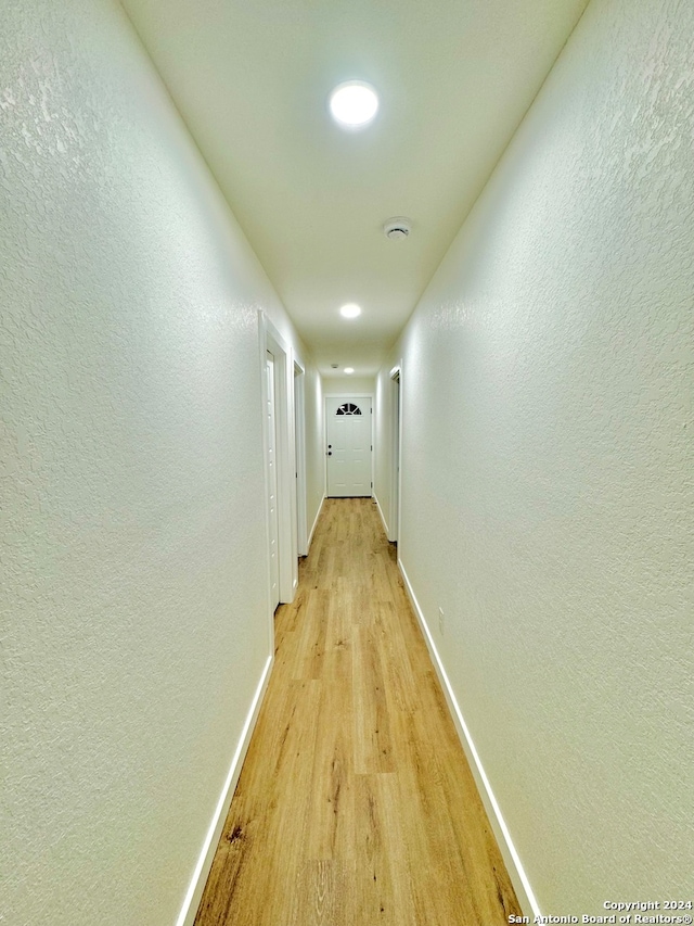 corridor with light hardwood / wood-style flooring