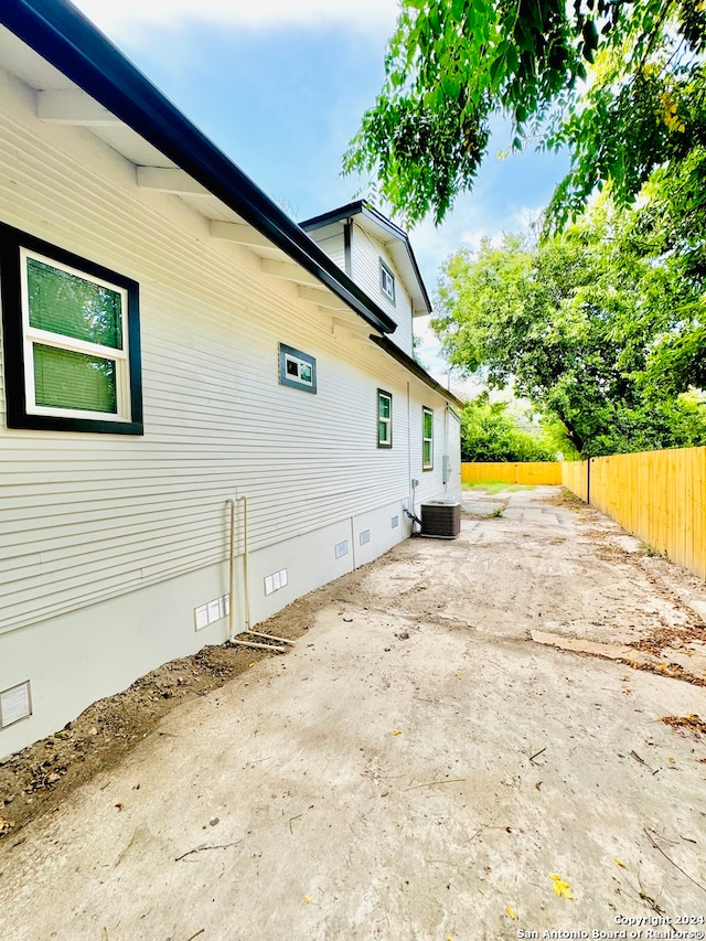 view of side of property featuring a patio area and central AC