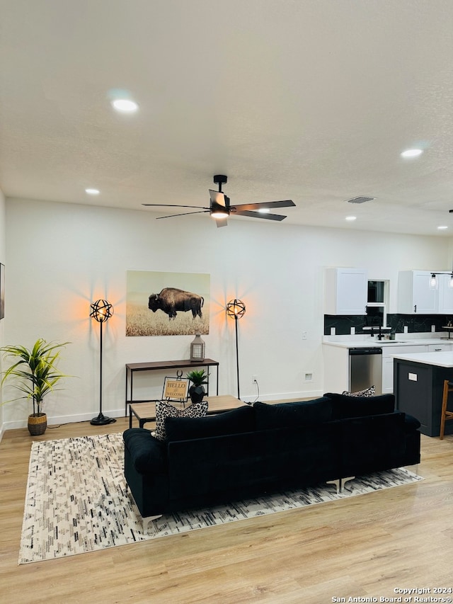 living room with ceiling fan and light wood-type flooring