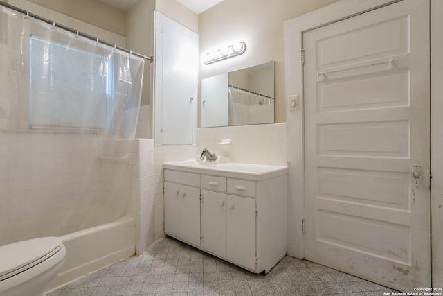 full bathroom featuring toilet, tile walls, shower / tub combo, decorative backsplash, and vanity