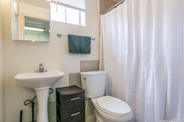 bathroom with a shower with shower curtain and toilet