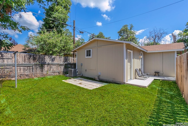 rear view of house featuring a yard and central air condition unit