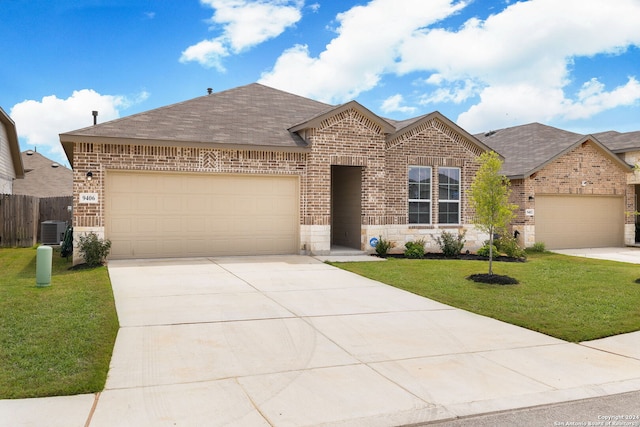 view of front of home featuring cooling unit, a garage, and a front yard