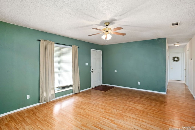 unfurnished room featuring ceiling fan, a textured ceiling, baseboards, and wood finished floors