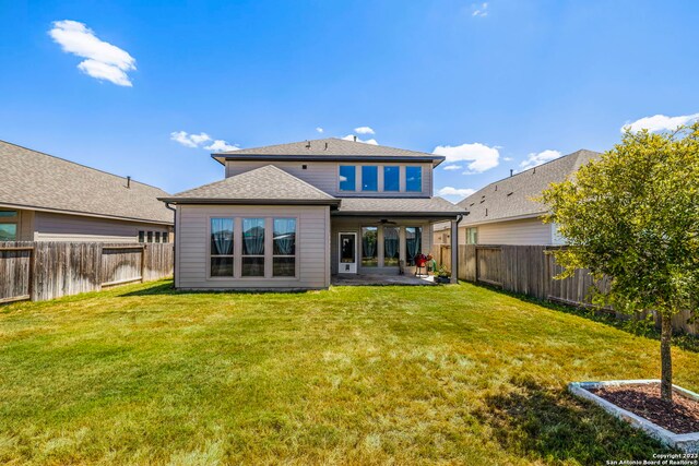 rear view of property with a lawn and a patio