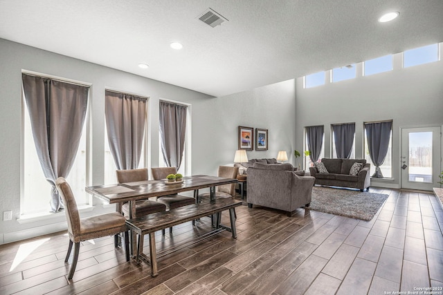 dining room featuring a textured ceiling and dark hardwood / wood-style floors