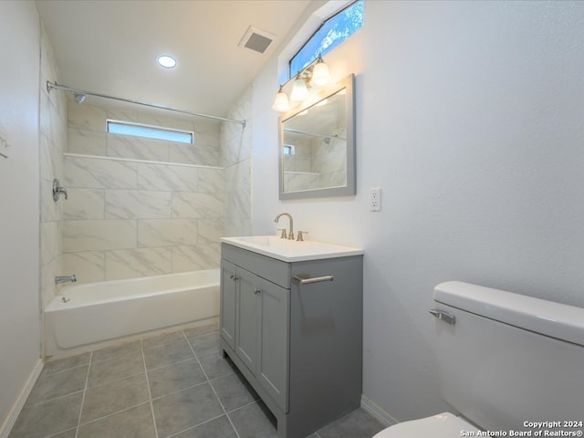 full bathroom with tiled shower / bath, vanity, toilet, and tile patterned floors