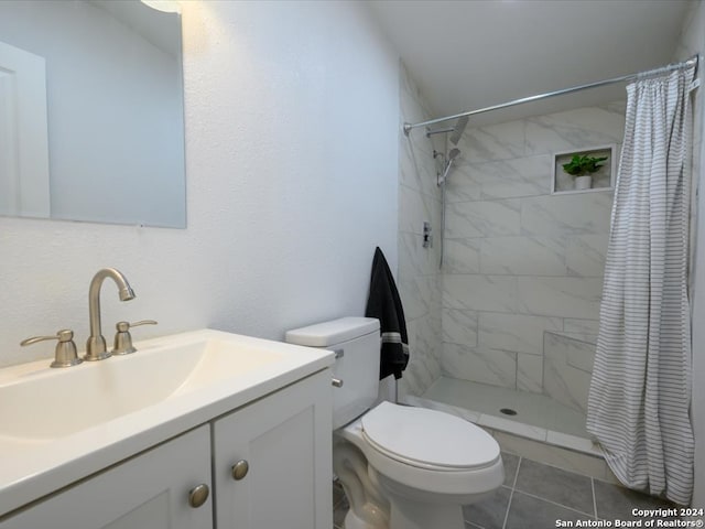 bathroom featuring tile patterned floors, a shower with curtain, toilet, and vanity