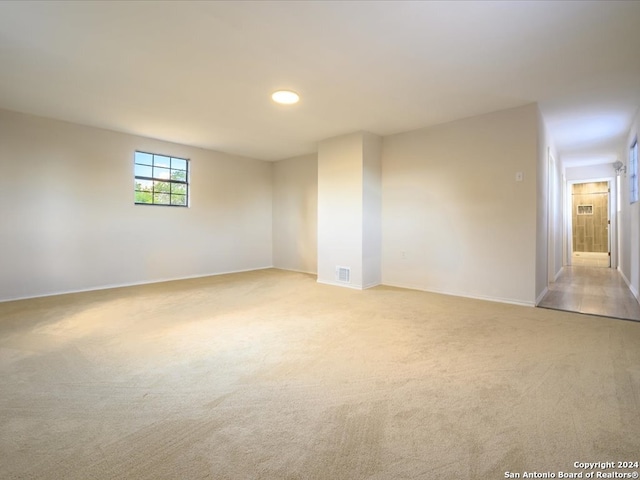 unfurnished room featuring light carpet