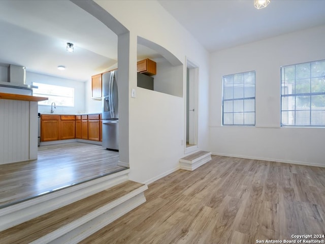 unfurnished living room with light wood-type flooring and sink