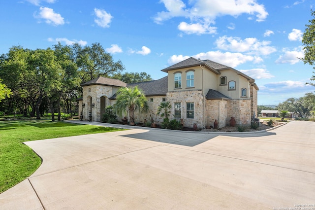 mediterranean / spanish home with a front lawn