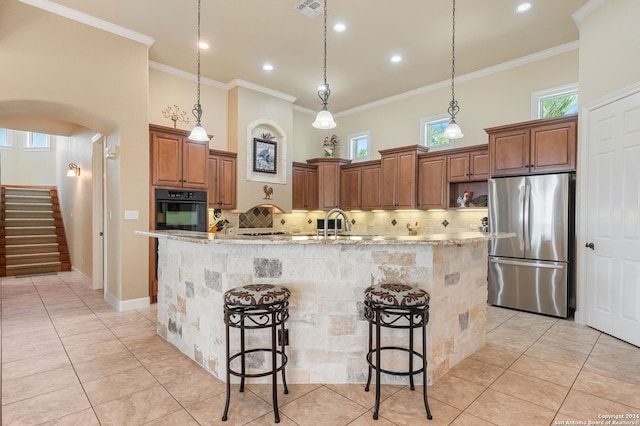 kitchen featuring a breakfast bar area, stainless steel fridge, oven, and a spacious island