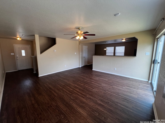 unfurnished living room with ceiling fan, dark hardwood / wood-style floors, and a textured ceiling