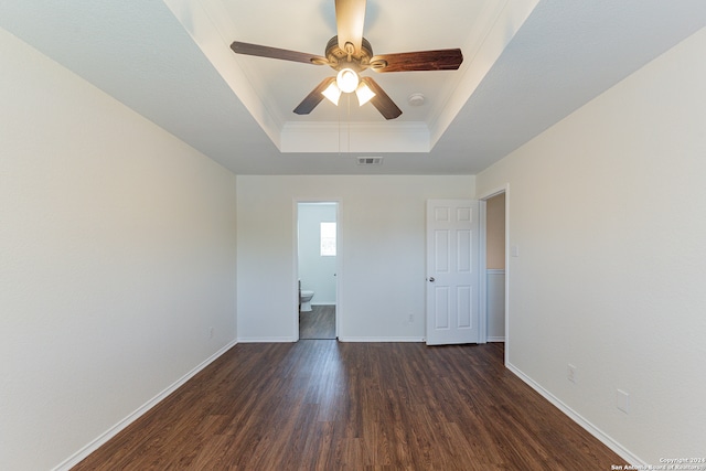 spare room with a tray ceiling, ceiling fan, and dark hardwood / wood-style floors