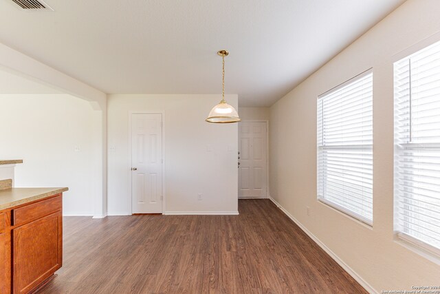 unfurnished dining area with dark hardwood / wood-style flooring