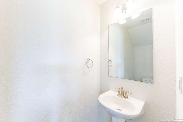 bathroom featuring vaulted ceiling and sink