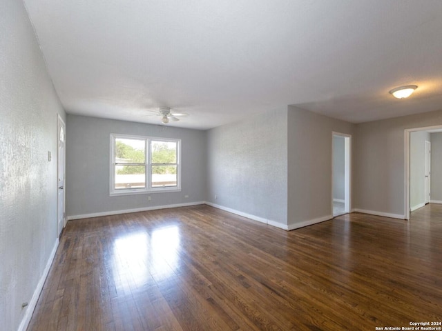 unfurnished room with ceiling fan and dark hardwood / wood-style flooring