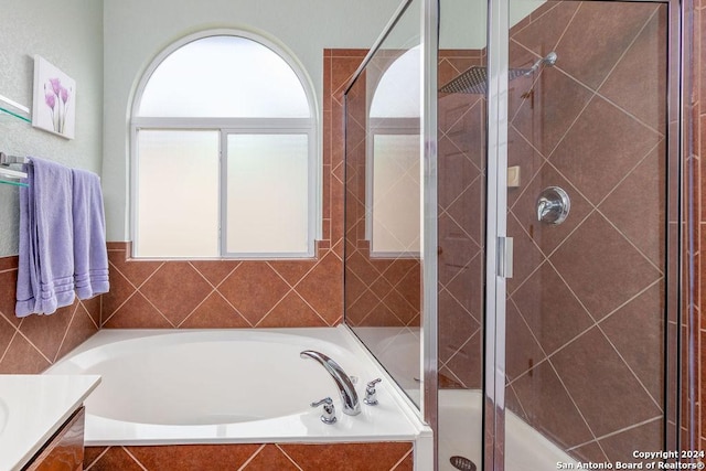 full bath featuring a garden tub, a shower stall, and vanity