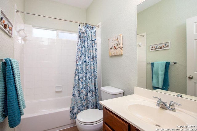 full bath with a textured wall, vanity, shower / bath combination with curtain, and toilet