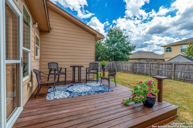 wooden deck with a yard and fence