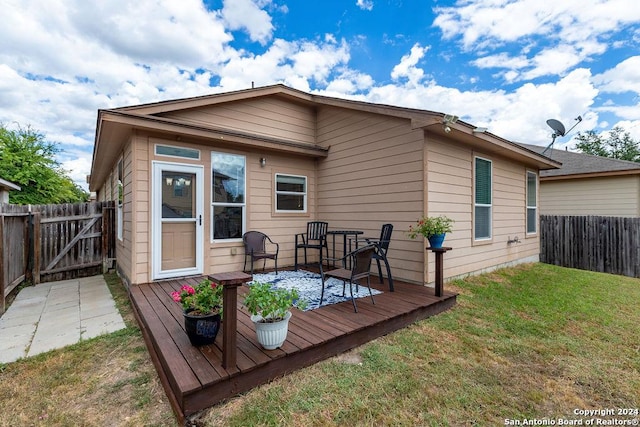 back of house featuring a deck, a yard, and fence