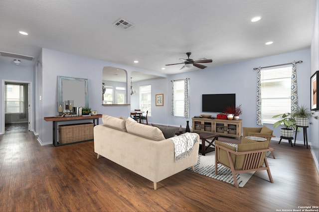 living area with arched walkways, ceiling fan, recessed lighting, dark wood-type flooring, and visible vents