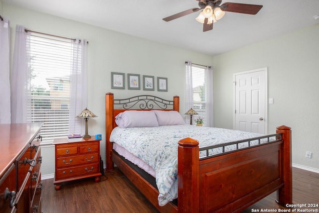 bedroom with a ceiling fan, dark wood-style flooring, and baseboards