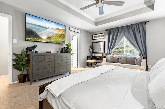 carpeted bedroom featuring ceiling fan, a raised ceiling, and ornamental molding