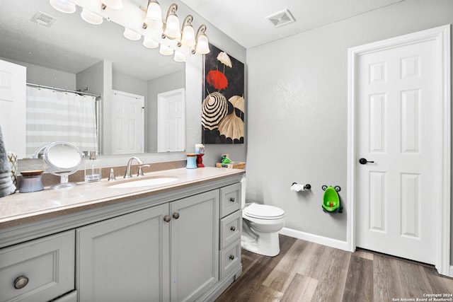 bathroom with vanity, toilet, and hardwood / wood-style flooring