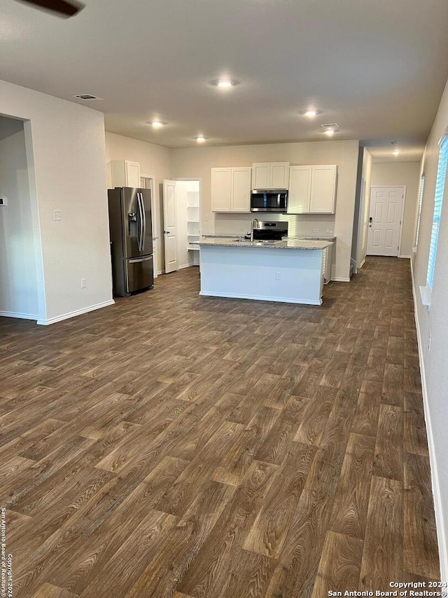 kitchen featuring white cabinetry, appliances with stainless steel finishes, dark hardwood / wood-style flooring, and an island with sink