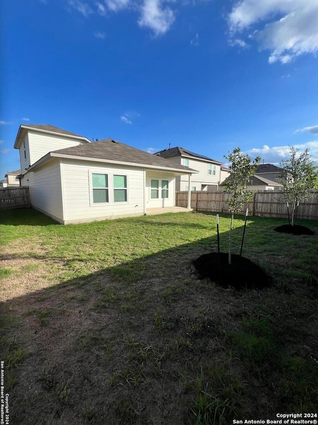 rear view of property with a yard