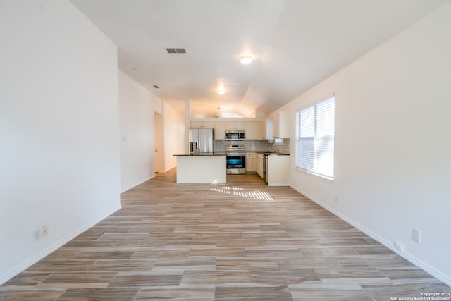 unfurnished living room with vaulted ceiling and light hardwood / wood-style flooring