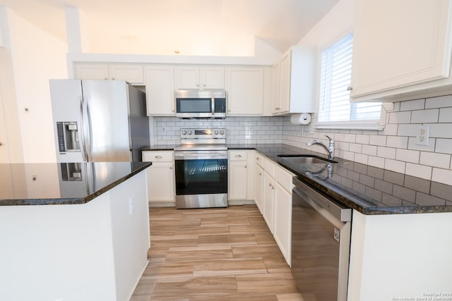 kitchen with sink, appliances with stainless steel finishes, white cabinets, and tasteful backsplash