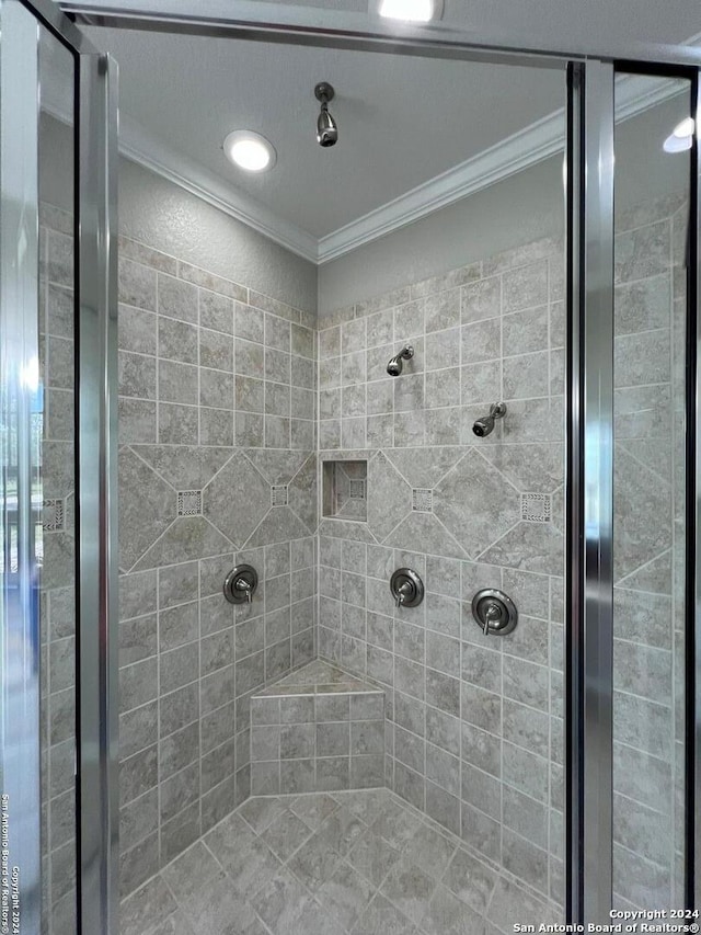 bathroom featuring a tile shower and ornamental molding