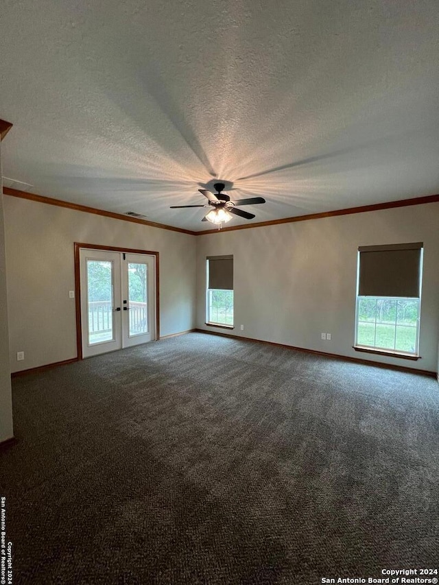 carpeted empty room with crown molding, a wealth of natural light, a textured ceiling, and ceiling fan