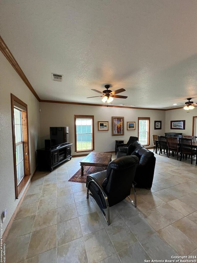 living room featuring a textured ceiling, ceiling fan, and crown molding