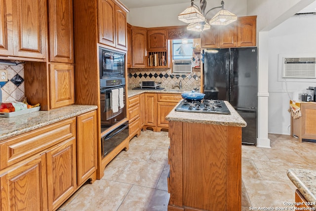 kitchen featuring a kitchen island, light stone countertops, black appliances, tasteful backsplash, and hanging light fixtures