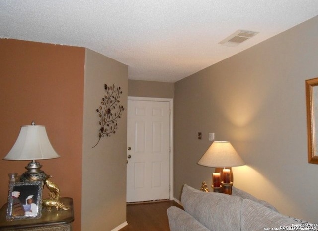 bedroom featuring a textured ceiling and wood-type flooring