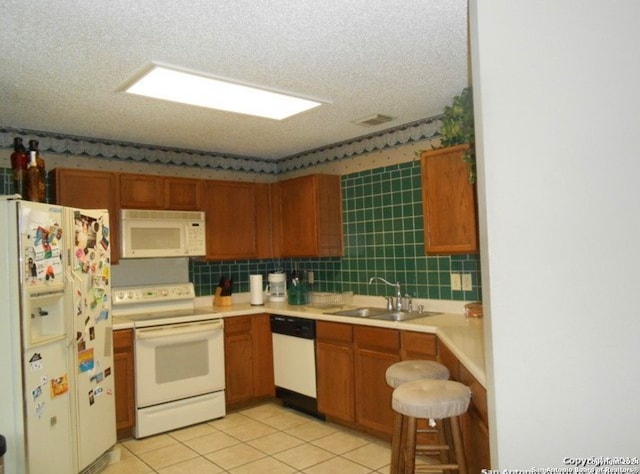 kitchen with sink, white appliances, decorative backsplash, and light tile patterned flooring