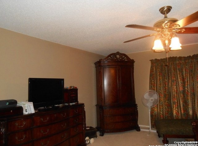 bedroom featuring a textured ceiling, ceiling fan, and light carpet