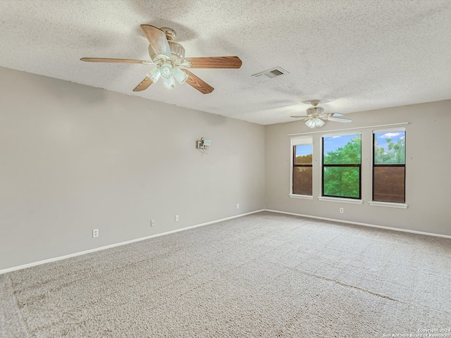 spare room featuring ceiling fan, light carpet, and a textured ceiling